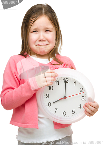 Image of Little girl is holding big clock