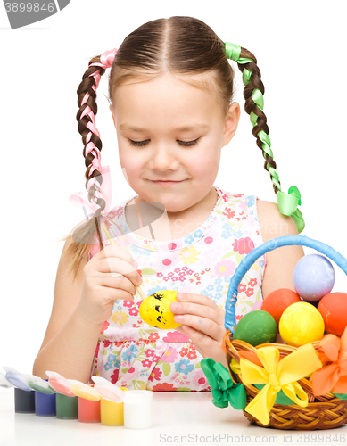 Image of Little girl is painting eggs preparing for Easter