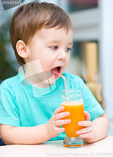 Image of Little boy with glass of orange juice