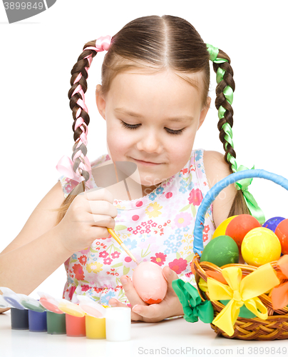 Image of Little girl is painting eggs preparing for Easter