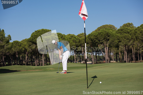 Image of golf player hitting shot at sunny day