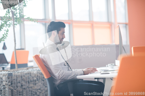 Image of young business man  working on desktop computer
