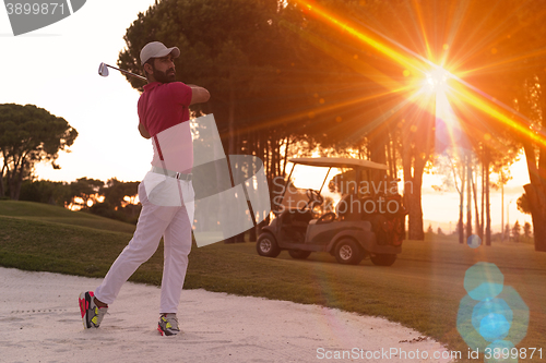 Image of golfer hitting a sand bunker shot on sunset