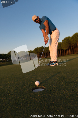 Image of golfer  hitting shot at golf course