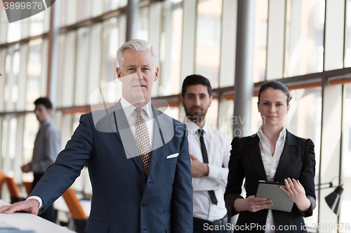Image of portrait of senior businessman as leader  with group of people i