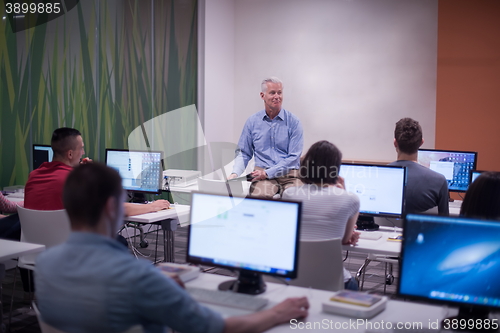 Image of teacher and students in computer lab classroom