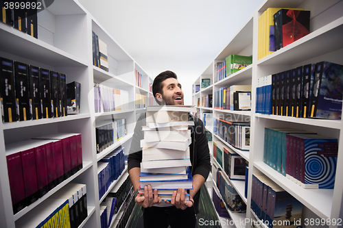 Image of Student holding lot of books in school library