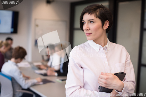 Image of hispanic businesswoman with tablet at meeting room