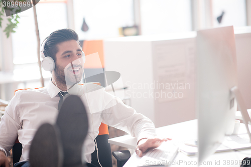 Image of relaxed young business man at office