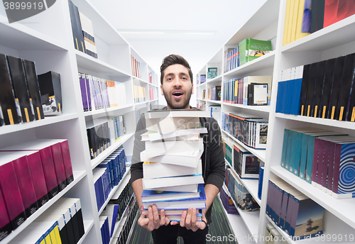 Image of Student holding lot of books in school library