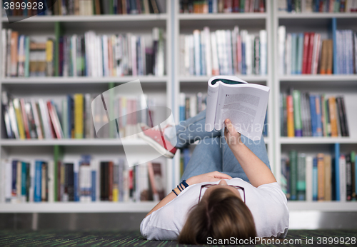 Image of female student study in library, using tablet and searching for 