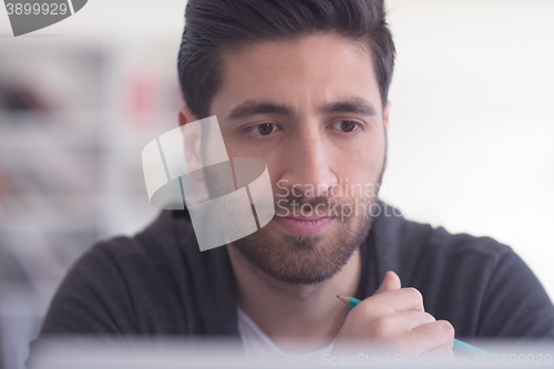 Image of student in school library using laptop for research