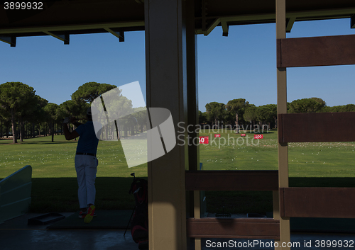 Image of golf player practicing shot on training