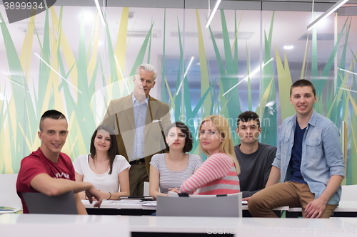 Image of portrait of  teacher with students group in background