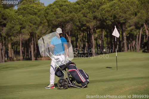 Image of golf player walking with wheel bag