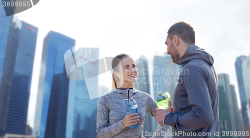 Image of smiling couple with bottles of water outdoors