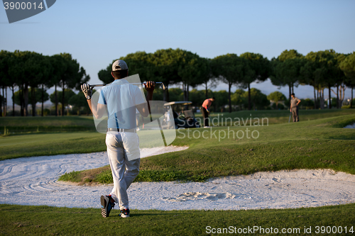 Image of golfer from back at course looking to hole in distance