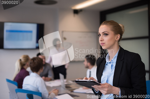 Image of business woman working on tablet at meeting room