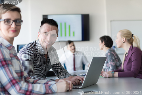 Image of young business couple working on laptop, businesspeople group on