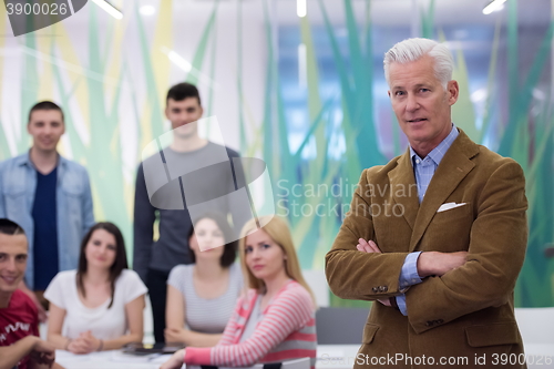 Image of portrait of  teacher with students group in background