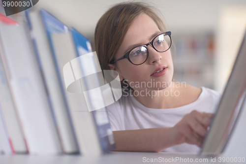 Image of portrait of famale student selecting book to read in library