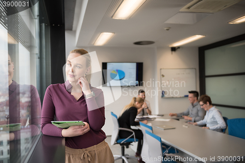 Image of blonde businesswoman working on tablet at office