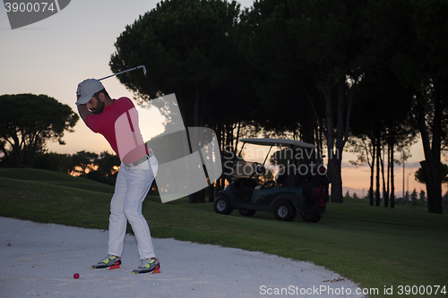 Image of golfer hitting a sand bunker shot on sunset