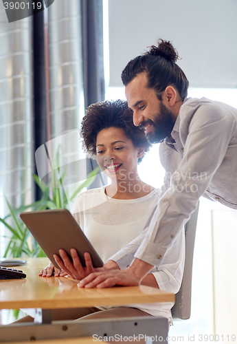 Image of happy creative team with tablet pc in office
