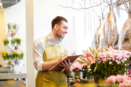 Image of florist man with clipboard at flower shop