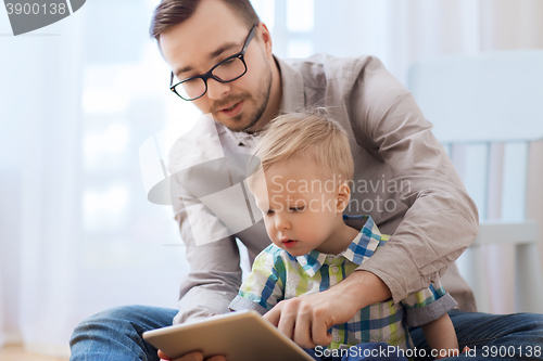 Image of father and son with tablet pc playing at home
