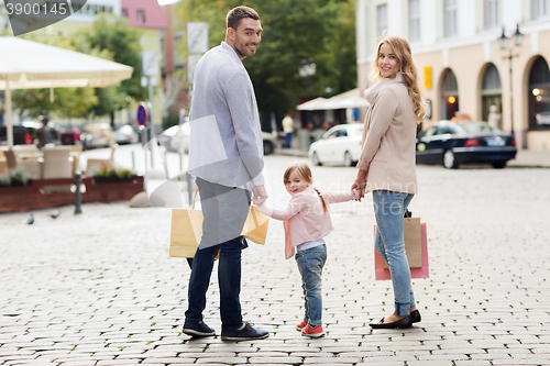 Image of happy family with child and shopping bags in city