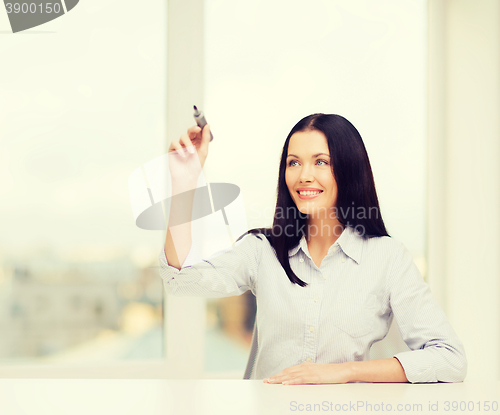 Image of smiling woman writing on virtual screen