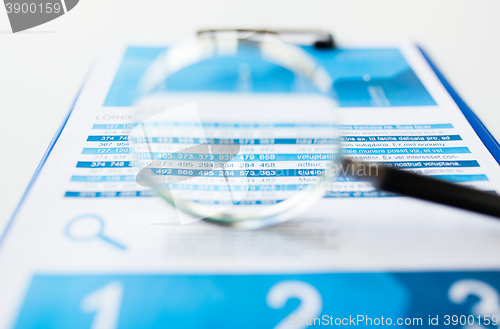 Image of close up of financial report and magnifying glass