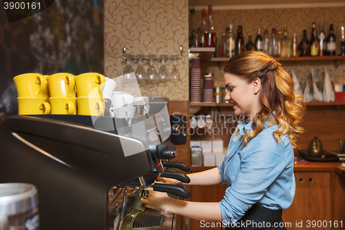 Image of barista woman making coffee by machine at cafe