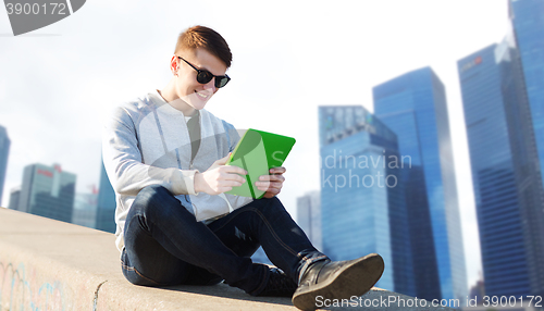 Image of happy young man with tablet pc in city