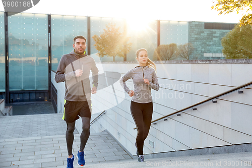 Image of happy couple running upstairs on city stairs