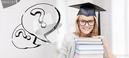 Image of happy student woman in mortarboard with books