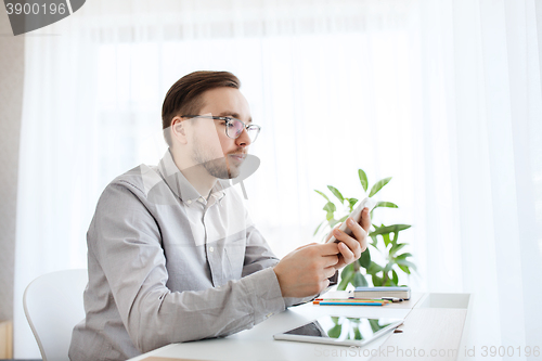 Image of creative male office worker texting on smarphone