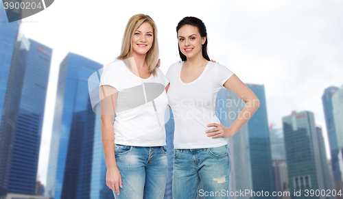 Image of group of happy different women in white t-shirts