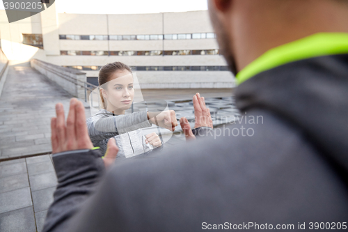Image of woman with trainer working out self defense strike