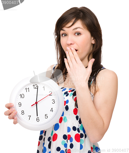 Image of Young woman is holding big clock