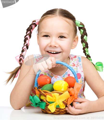 Image of Little girl with basket full of colorful eggs