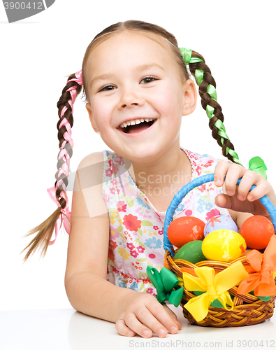 Image of Little girl with basket full of colorful eggs