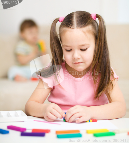 Image of Little girl is playing with plasticine