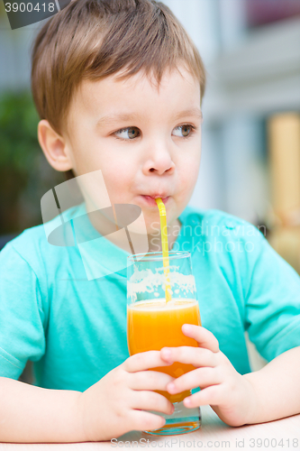 Image of Little boy with glass of orange juice