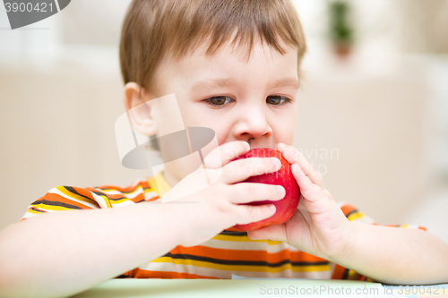 Image of Little boy is eating apple