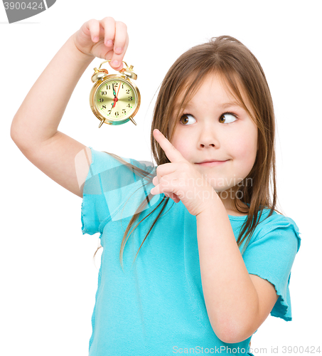 Image of Little girl is holding small alarm clock