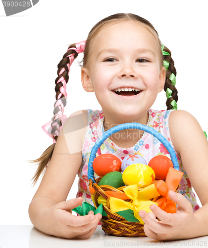Image of Little girl with basket full of colorful eggs