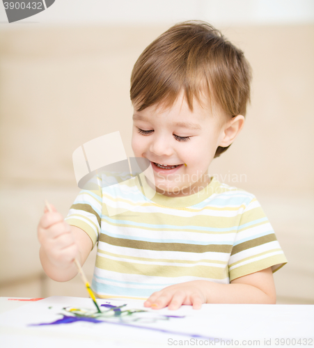 Image of Little boy is playing with paints