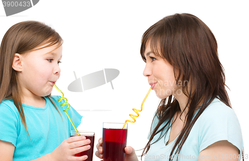 Image of Mother and her daughter are drinking juice